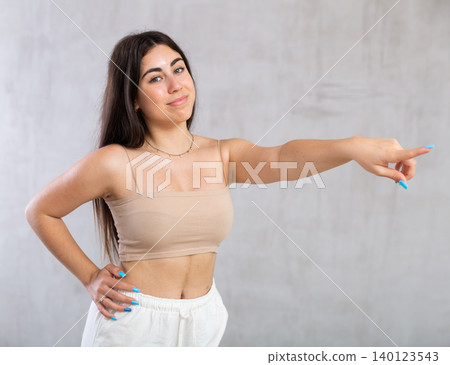 Young smiling woman gesturing in studio 140123543