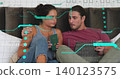 Holding green passport woman left leaning on dark headboard, man right checking tablet, teal holo 140123575