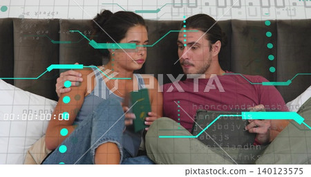 Holding green passport woman left leaning on dark headboard, man right checking tablet, teal holo Holding green passport woman left leaning on dark headboard, man right checking tablet, teal holo 140123575