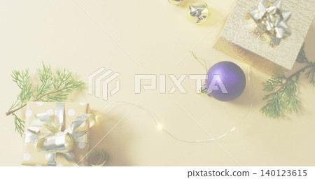 Styling flatlay with matte purple bauble on beige tabletop, wrapped gifts, fairy lights, copy space Styling flatlay with matte purple bauble on beige tabletop, wrapped gifts, fairy lights, copy space 140123615