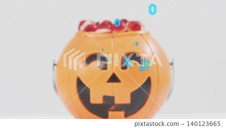 Displaying orange jack-o'-lantern bucket holding red candy on white tabletop, showing cyan overlay Displaying orange jack-o'-lantern bucket holding red candy on white tabletop, showing cyan overlay 140123665