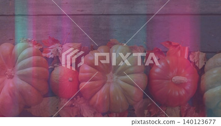 Displaying large ribbed pumpkins with small gourd on weathered plank, showing magenta cyan light 140123677
