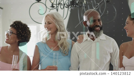 Raising champagne flutes, four guests wearing dresses and white shirt standing at home, chandelier Raising champagne flutes, four guests wearing dresses and white shirt standing at home, chandelier 140123812