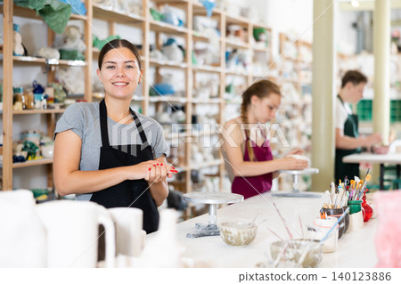Young woman teacher posing in ceramic workshop Young woman teacher posing in ceramic workshop 140123886