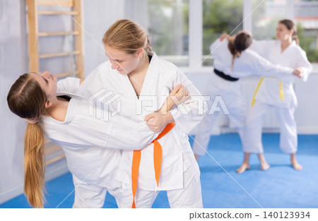 Adolescent female karateka honing fighting techniques during kumite Adolescent female karateka honing fighting techniques during kumite 140123934