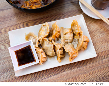 Grilled gyoza dumplings, bowl of soy sauce and chopsticks Grilled gyoza dumplings, bowl of soy sauce and chopsticks 140123938
