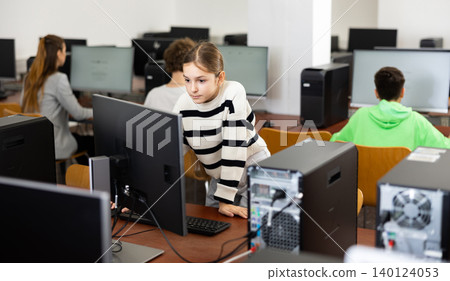 Young girl learning to use personal computer during lesson Young girl learning to use personal computer during lesson 140124053