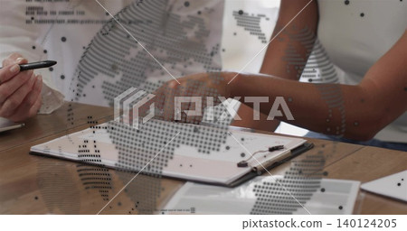 Reviewing women in white tops pointing at clipboard at meeting table, showing ring and map overlay Reviewing women in white tops pointing at clipboard at meeting table, showing ring and map overlay 140124205