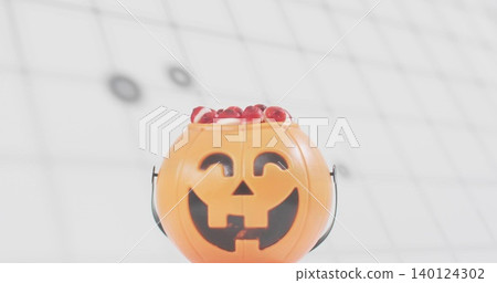 Showing orange pumpkin bucket with face, black handle spilling red candies under ceiling grid 140124302