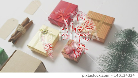 Displaying wrapped boxes forming holiday scene on white table, with bows, tags, cinnamon, evergreen Displaying wrapped boxes forming holiday scene on white table, with bows, tags, cinnamon, evergreen 140124324