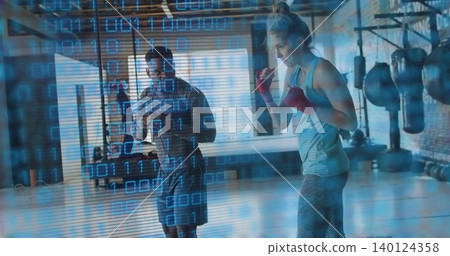 Coaching coach observing boxer standing in gym with binary overlay wearing sportswear and red wraps Coaching coach observing boxer standing in gym with binary overlay wearing sportswear and red wraps 140124358