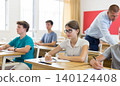 Young students sitting at desks in classroom 140124408