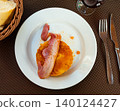 There is portion of casserole made from boiled potatoes and cabbage on plate. 140124427
