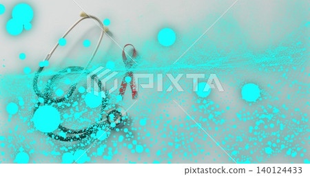 Showing stethoscope with red awareness ribbon coiling on white tabletop, cyan splatter overlay 140124433