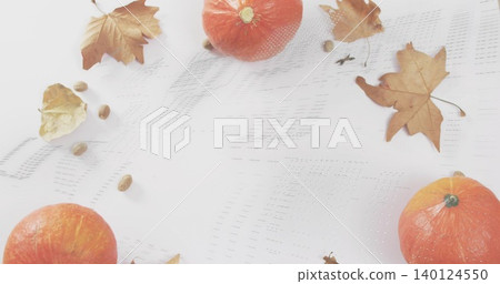 Displaying mini orange pumpkins on tabletop with white eyelet cloth, dried maple leaves and seeds 140124550
