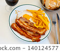 Delicious breakfast - pork belly and fried eggs with fries closeup 140124577