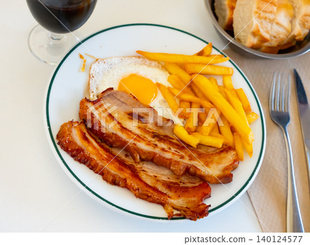 Delicious breakfast - pork belly and fried eggs with fries closeup Delicious breakfast - pork belly and fried eggs with fries closeup 140124577