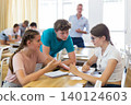 Teenagers working in small groups during lesson at school 140124603