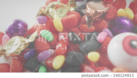 Shimmering nonpareil raspberries and candy pieces sparkling on flat white plate with eyeball candy 140124913