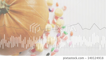 Showing large orange pumpkin sitting left on white table, with yellow candies and grid overlay Showing large orange pumpkin sitting left on white table, with yellow candies and grid overlay 140124918