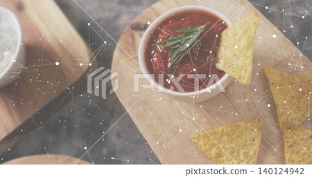 Featuring white bowl of red salsa with rosemary on wooden board, chips and constellation overlay Featuring white bowl of red salsa with rosemary on wooden board, chips and constellation overlay 140124942