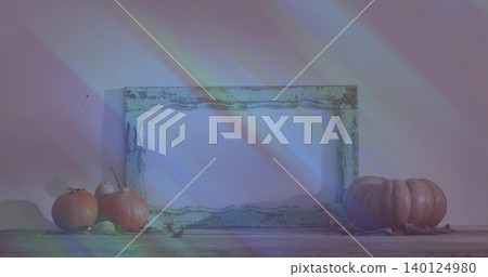 Showing distressed wood frame leaning on painted wall, with pumpkins, dried leaves, prism streaks Showing distressed wood frame leaning on painted wall, with pumpkins, dried leaves, prism streaks 140124980