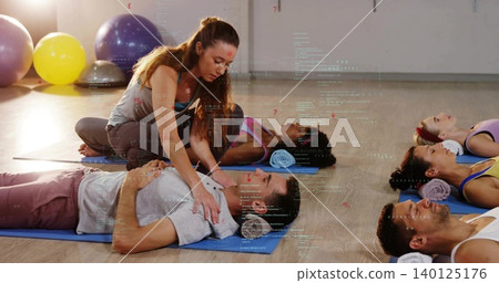 Kneeling instructor guiding man breathing in studio with blue mats and digital overlay, in leggings Kneeling instructor guiding man breathing in studio with blue mats and digital overlay, in leggings 140125176