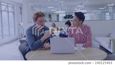 Talking colleagues in blue shirt and red-striped blouse using laptop and holding mugs in office Talking colleagues in blue shirt and red-striped blouse using laptop and holding mugs in office 140125403