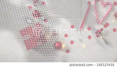 Showing red-gift-white-ribbon sitting left-center on wood-table, candy, baubles, lights, halftone 140125438