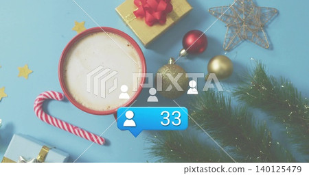 Displaying red-rimmed frothy cup sitting left on pale blue table, with candy cane, gifts, social 33 140125479