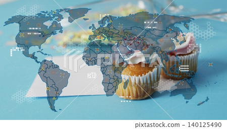 Showing two frosted cupcakes, liners on blue tabletop with white card and map overlay, copy space 140125490