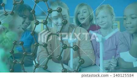 Gathering children and educator around classroom table, examining wind turbines and molecular model 140125584