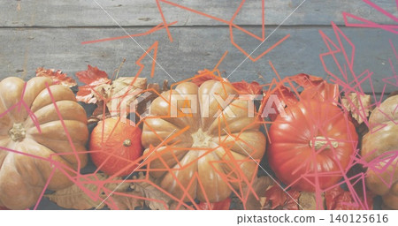 Showing tan ribbed pumpkin, orange gourds and dried leaves on blue-gray plank, pink orange overlay Showing tan ribbed pumpkin, orange gourds and dried leaves on blue-gray plank, pink orange overlay 140125616