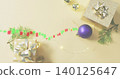 Displaying gold polka-dot gift with metal bow on pale beige table, fairy lights, digital trail 140125647