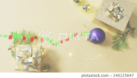 Displaying gold polka-dot gift with metal bow on pale beige table, fairy lights, digital trail Displaying gold polka-dot gift with metal bow on pale beige table, fairy lights, digital trail 140125647