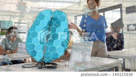 Hovering blue hexagon brain overlay centered in classroom, presenter in blue blouse holding tablet Hovering blue hexagon brain overlay centered in classroom, presenter in blue blouse holding tablet 140125836