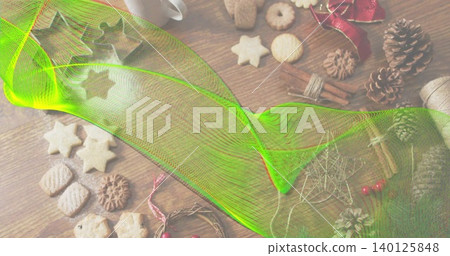 Sweeping neon-green mesh overlay spanning wood table, obscuring star cookies, pine cones, cinnamon Sweeping neon-green mesh overlay spanning wood table, obscuring star cookies, pine cones, cinnamon 140125848
