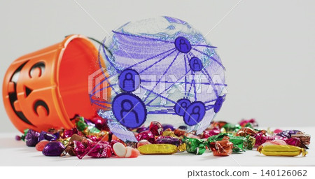 Showing translucent globe over white tabletop, orange jack-o'-lantern candy bucket spilling candies Showing translucent globe over white tabletop, orange jack-o'-lantern candy bucket spilling candies 140126062