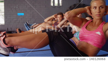 Woman in pink top doing bicycle crunches in studio on mats with thigh strap, copy space Woman in pink top doing bicycle crunches in studio on mats with thigh strap, copy space 140126068