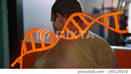 Displaying shirtless adult male standing in gym, showing orange DNA double-helix across back 140126078