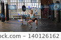 Lifting midadult woman in blue bra shorts holding barbell overhead squatting at gym with AR metrics 140126162