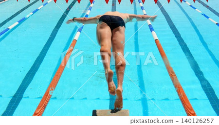 Diving male swimmer launching from block into outdoor pool, wearing dark briefs and lane ropes Diving male swimmer launching from block into outdoor pool, wearing dark briefs and lane ropes 140126257