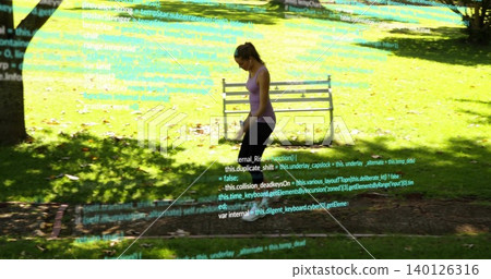 Walking woman purple tank black leggings checking cell in sunny park, buds code overlay, copy space Walking woman purple tank black leggings checking cell in sunny park, buds code overlay, copy space 140126316