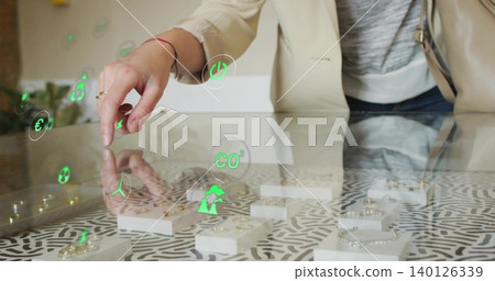 Leaning woman in beige blazer reaching ring on glass display at boutique with green AR icons Leaning woman in beige blazer reaching ring on glass display at boutique with green AR icons 140126339