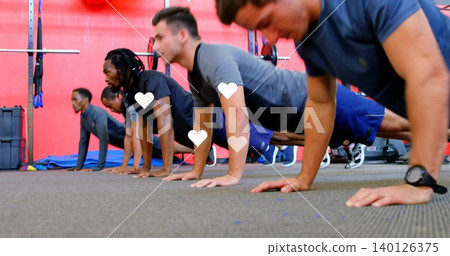 Performing push-ups five men wearing athletic shirts and shoes on rubber gym floor, weight rack Performing push-ups five men wearing athletic shirts and shoes on rubber gym floor, weight rack 140126375