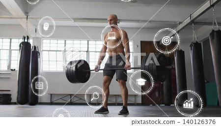Lifting shirtless man in dark shorts black shoes performing deadlift at gym with barbell, HUD 140126376