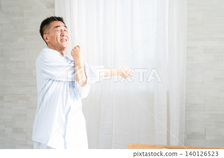 A man wakes up and stretches on his bed A man wakes up and stretches on his bed 140126523