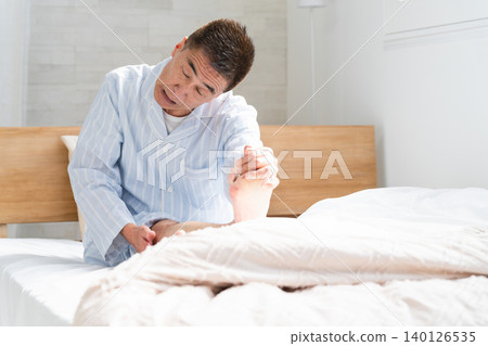 一名男子在床上醒來，雙腿抽筋 140126535