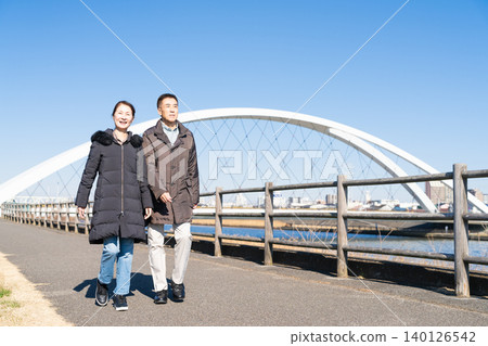 A middle-aged couple walking along a promenade A middle-aged couple walking along a promenade 140126542
