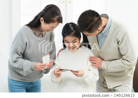 A girl receiving New Year's money from her grandfather and grandmother A girl receiving New Year's money from her grandfather and grandmother 140126615